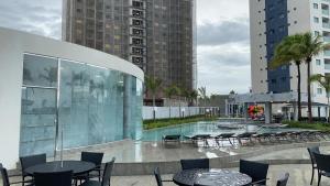 a patio with tables and chairs and a pool at SALINAS EXCLUSIVE RESORT in Salinópolis