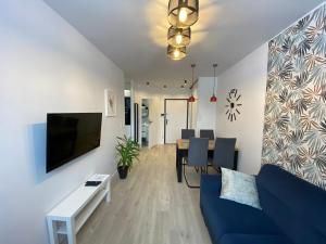 uma sala de estar com um sofá azul e uma mesa em Apartament MORENA em Gdansk