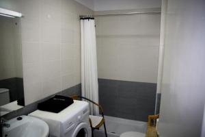 a bathroom with a sink and a washing machine at Peñamar Apartamentos in Puerto del Carmen