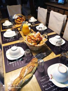 a table topped with a table with a basket of bread at La Chaumière in Saint-Martin-Saint-Firmin