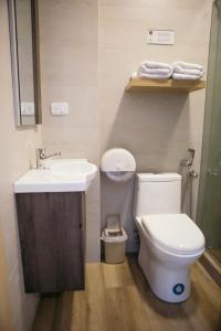 a bathroom with a white toilet and a sink at The Park Hotel in Guayaquil