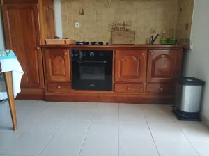 a kitchen with a wooden cabinet with a dishwasher at Mandariniers 97232 in Le Lamentin