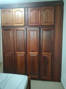 a wooden cabinet with wooden doors in a room at Mandariniers 97232 in Le Lamentin