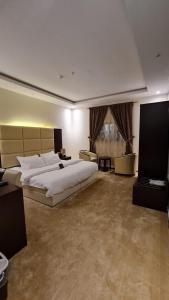 ein großes Schlafzimmer mit einem großen Bett und einem Fenster in der Unterkunft تــرامونتــان in Ha'il