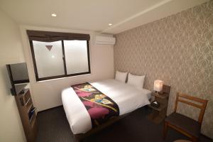 a small bedroom with a bed and a window at Laon Inn Gion Nawate in Kyoto
