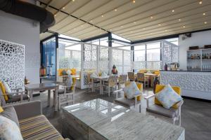 a restaurant with tables and chairs and windows at Crowne Plaza Doha - The Business Park by IHG in Doha