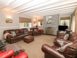 a living room with leather furniture and a fireplace at The Old Barn in Alton