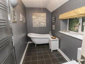 a bathroom with a white tub and a window at The Old Barn in Alton +22 photos