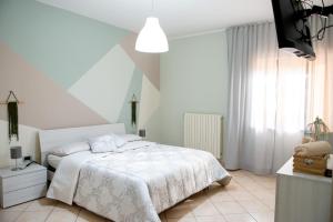 Un dormitorio blanco con una cama blanca y una ventana en IL NIDO DEI NONNI -Casa Vacanze, en Paglieta