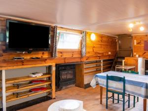 uma sala de estar com uma televisão e uma lareira numa pequena casa em Comfy Houseboat in Florennes next to the Forest em Florennes
