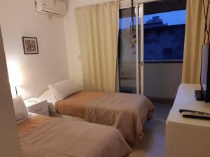 a hotel room with two beds and a window at Practico y Confortable Dpto Temporario Balcarce in San Miguel de Tucumán