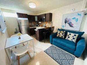 a living room with a blue couch and a kitchen at Charming Retreat with Patio Access and FREE Laundry in Ponce
