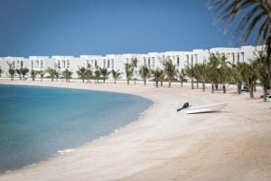 una playa con un barco en la arena y un edificio en Live in the middle of Lagoons and Sea en Ras al-Khaimah