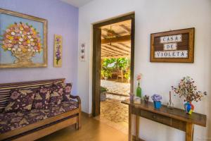 ein Wohnzimmer mit einem Sofa und einem Tisch in der Unterkunft Casa de Violeta Pousada in Tiradentes