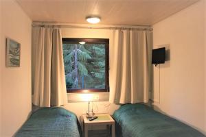ein Schlafzimmer mit zwei Einzelbetten und einem Fenster in der Unterkunft Your Hotels in Nuppola