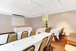 a conference room with tables and chairs and a whiteboard at Days Inn by Wyndham Tucson City Center in Tucson