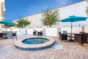a hot tub in a patio with tables and umbrellas at La Quinta by Wyndham Tampa Central in Tampa