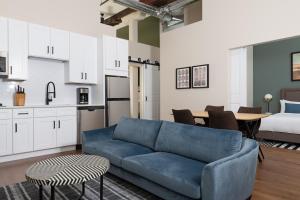 uma sala de estar com um sofá azul e uma cozinha em Sonder Jewelers Row em Chicago