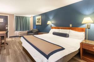プレザント・プレイリーにあるValue Inn Kenosha I-94 - Exit 344の青い壁の大きなベッドが備わるホテルルームです。