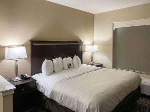 a hotel room with a large white bed with two lamps at Comfort Suites Kings Bay Naval Base Area in Kingsland