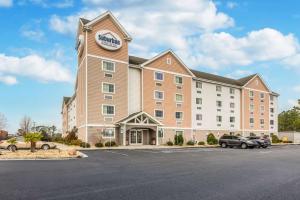 a hotel with cars parked in a parking lot at Suburban Studios Near Camp Lejeune in Jacksonville