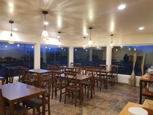 a restaurant with wooden tables and chairs and windows at Hotel Casa Verde in Puerto Natales