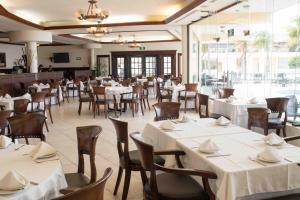 um restaurante com mesas e cadeiras com toalhas de mesa brancas em Hotel Arenas del Mar Resort em Tampico