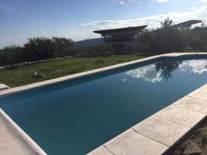 a large blue swimming pool in front of a house at Refugio: El Llamado in Villa Las Rosas
