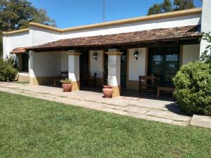 a porch of a house with a table and chairs at Hospedaje El Rincon in San Antonio de Areco
