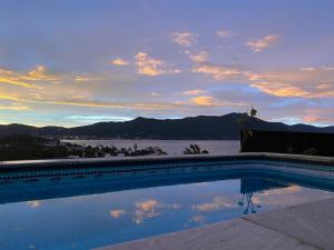 a swimming pool with a view of the water at Aloha spa in Florianópolis