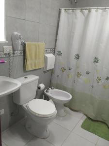 een badkamer met een toilet, een wastafel en een douchegordijn bij north beach depto 6 in Colón