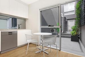 a kitchen with a table and chairs in a room at Bondi Beach Studios Suite in Sydney