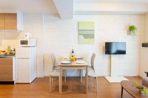 a kitchen with a table and chairs in a kitchen at BON Condominium Umeda in Osaka