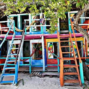 ein farbenfrohes Haus mit zwei Stühlen und einer Leiter in der Unterkunft The Wizard & Bar BARU in Playa Blanca