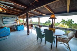 a dining room with a table and chairs and a balcony at Aeolian Ranch Guest house in Kailua-Kona