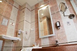 a bathroom with a shower with a sink and a mirror at Hotel Bristol in Chalons en Champagne