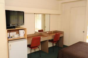 a hotel room with two beds and a television at Peninsula Motor Inn in Tyabb