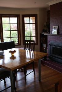 a living room with a wooden table and a fireplace at Yallambee B&B in Bundanoon