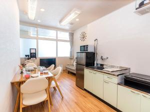 a kitchen and dining room with a table and chairs at El Sol Town Okinawa in Chatan