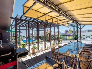 a patio with a table and chairs on a deck at El Sol Town Okinawa in Chatan