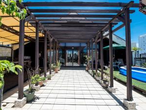 uma passagem coberta com vasos de plantas e uma piscina em El Sol Town Okinawa em Chatan