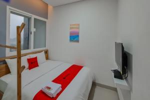 een witte slaapkamer met een bed en een televisie bij RedDoorz Plus @ Batutulis Bogor in Bogor