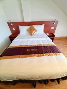 1 dormitorio con 1 cama grande y cabecero de madera en Rinny Hotel en Dalat