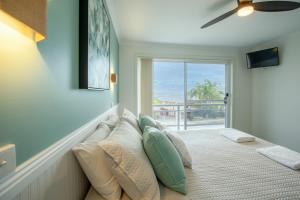 um quarto com um sofá com almofadas e uma janela em Top Of The Quays em Merimbula