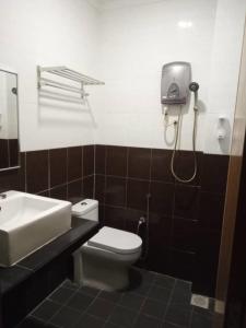 y baño con aseo blanco y lavamanos. en Sky View Hotel Dengkil PUTRAJAYA, en Kampung Dengkil