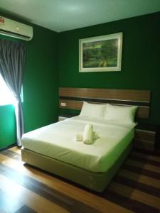 1 dormitorio con 1 cama grande y paredes verdes en Sky View Hotel Dengkil PUTRAJAYA, en Kampung Dengkil