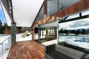 a glass house with a view of the snow at Lake Views at Antler Lodge in Lake Tekapo
