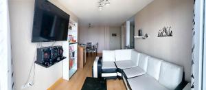 sala de estar con sillas blancas y TV de pantalla plana en Vista Ashul Apartment 02 dormitorios, en Lima