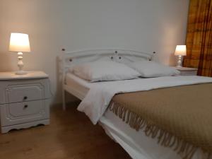 een slaapkamer met een wit bed en 2 lampen bij LUXURY apartment in the City Center with a terrace in Mukacheve