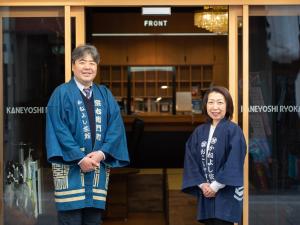 a man and a woman standing in front of a store at Kaneyoshi Ryokan in Osaka
